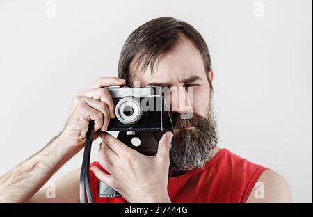 Serious bearded man with camera. Photographer self portrait with vintage photo camera. Stock Photo