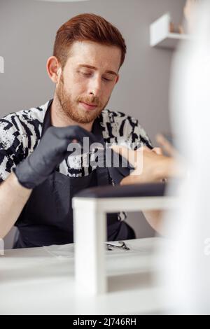 Professional manicure master working on nails in salon Stock Photo