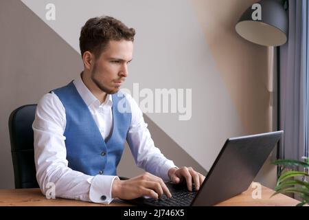 Businessman thinking about online project, looking at laptop at workplace, dreamy professional considering decision to sit at desktop with computer, student looking for new idea inspiration in office Stock Photo