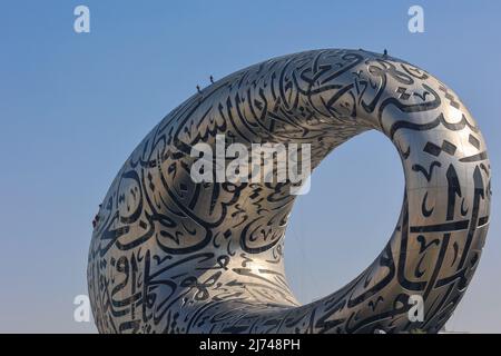 UAE, Dubai - November 28, 2021: People wash windows at Museum of Future. Climbers hang on ropes. Modern futuristic Museum built according designed by architect Shaun Killa. High quality photo Stock Photo