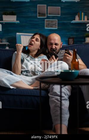 Irritated man and woman losing online videogames challenge on television console, feeling frustrated about lost gaming competition. Angry couple using cyberspace for leisure activity. Stock Photo