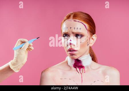 Patient in bandages. Nurses and young woman in studio pink background Stock Photo