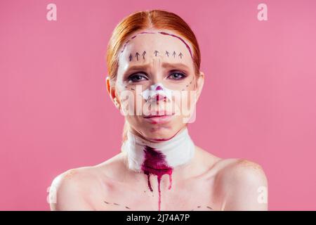 Patient in bandages. Nurses and young woman in studio pink background Stock Photo