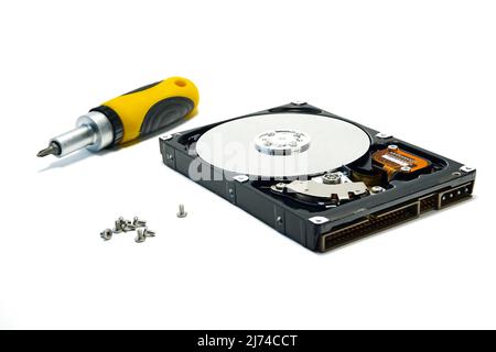 Open hard drive and screwdriver isolated on white background closeup. Computer hard drive HDD. computer memory. Stock Photo