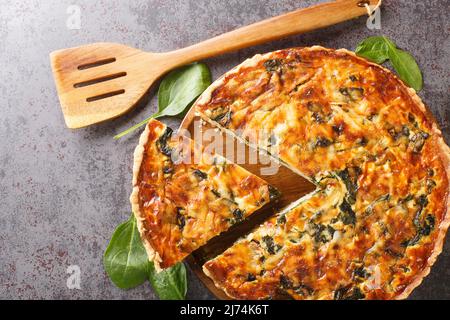 Quiche Florentine is a fresh spinach quiche baked in a homemade pie crust to serve for brunch or breakfast for dinner on gray table close-up. Hotizont Stock Photo