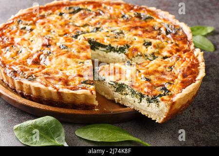 Quiche Florentine is a fresh spinach quiche baked in a homemade pie crust to serve for brunch or breakfast for dinner on gray table close-up. Hotizont Stock Photo