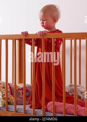 little girl stands in bed after waking up Stock Photo