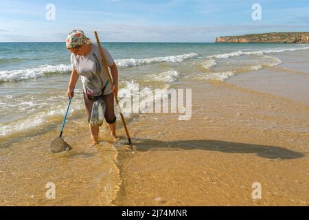 Woman fishing worms, crabs and other crustaceans, Portugal, Algarve Stock Photo