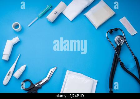 First Aid Kit With Medical Equipment On Blue Background Stock Photo