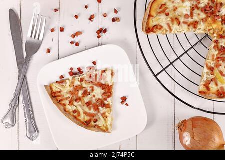 Slice of taditional food 'Tarte Flambee' or 'Flammkuchen' from German-French Alsace border region Stock Photo