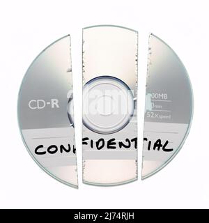 Shredded broken CD with Confidential written on it isolated on a white background Stock Photo