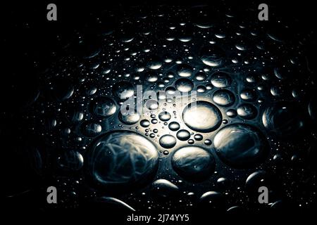 Abstract dark shiny background with droplets. Droplets background with a dim spotlight. Stock Photo