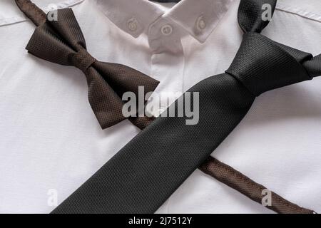 Black tie and bow tie on white shirt, men fashion concept, black color accessories,  men clothing idea, sitting view Stock Photo