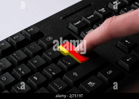 Pressing enter button with Germany flag, represents a cyber-attack of Germany, metaphor of learning German language, black keyboard close up, Deutsch Stock Photo