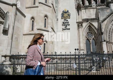 London, UK, 6th May, 2022. A woman passes the Royal Courts of Justice as English Defence League founder Tommy Robinson, whose real name is Stephen Yaxley-Lennon attends his contempt of court hearing. He failed to show up for court in March over unpaid legal costs after losing a libel case, brought against him by Syrian teenager Jimal Hijazi and the court heard it was due to mental health issues. Robinson was asked to return to the High Court in June to face questioning over his finances. Credit: Eleventh Hour Photography/Alamy Live News Stock Photo