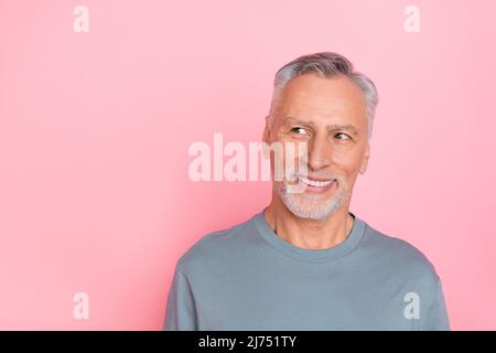 Photo of confident dreamy man pensioner dressed grey shirt looking empty space isolated pink color background Stock Photo