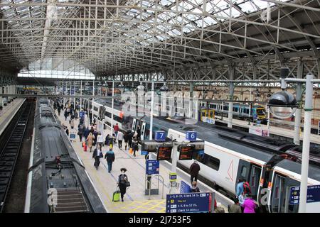 View of trains at platforms at Manchester Piccadilly railway station on  5th May 2022 with passengers on platforms leaving and boarding trains. Stock Photo