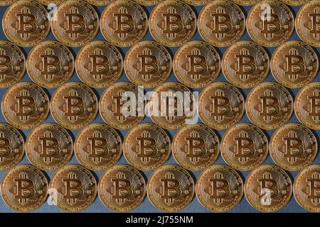 Coins of golden bitcoin, texture from coins on a gray background. Stock Photo