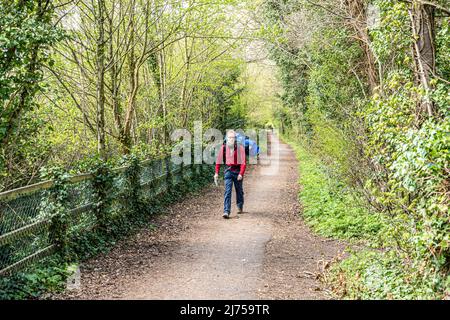 A hiker on the Cotswold Way National Trail on the old Stonehouse to Nailsworth Midland Railway line at Ebley, Gloucestershire, England UK Stock Photo