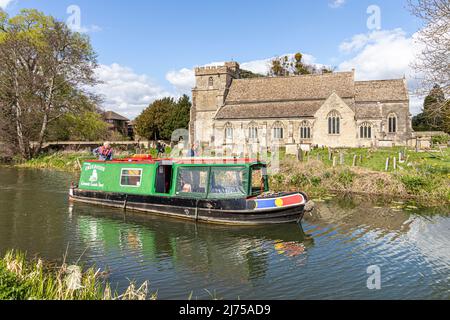 The Cotswold Canals Trust long boat Endeavour on the restored Stroudwater Canal passing St Cyr's Church, Stonehouse, Gloucestershire, England UK Stock Photo