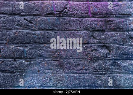 Colorful painted brick wall in city alley. Stock Photo