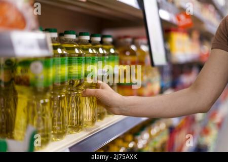 Woman buying cooking oil in supermarket, close-up Stock Photo
