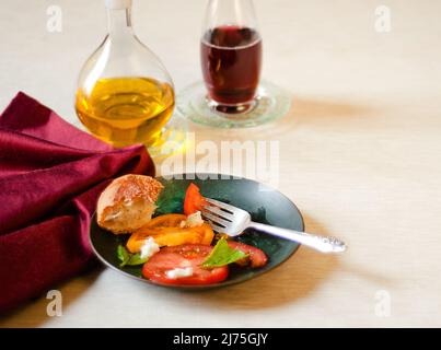 Caprese salad with tomatoes, basil, mozzarella, bread, oil and vinegar Stock Photo
