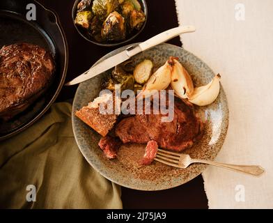 Black Angus Steak with Bread, Onions and Brussels Sprouts Stock Photo