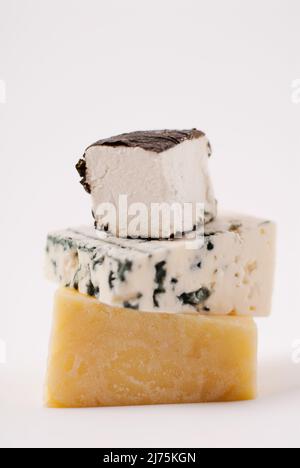 Stack of assorted gourmet cheeses Stock Photo