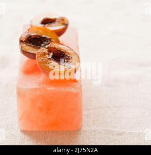 Grilled Peaches served on a Himalayan salt block Stock Photo