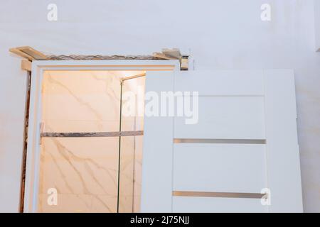 Installing door unit the door frame using a mounting foam. Stock Photo