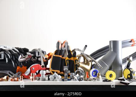 Sample of plumbing materials and tools on workbench and white isolated background. Front view. Horizontal composition. Stock Photo