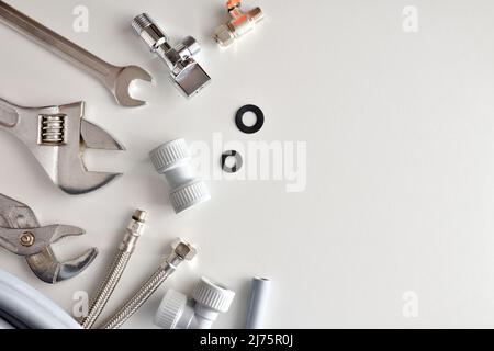 Plumbing background with tools and materials on white table. Top view. Horizontal composition. Stock Photo
