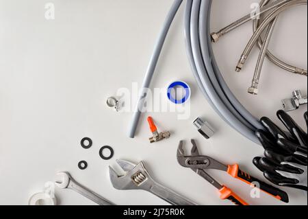 Group of plumbing materials and tools on white workbench. Top view. Horizontal composition. Stock Photo
