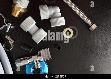 Concept of plumbing industrial technical service and revisions with notepad and tools and plumbing material on black table. Top view. Horizontal compo Stock Photo