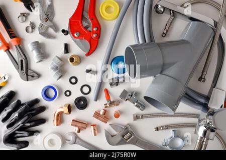 Sample of plumbing materials and tools on white workbench. Top view. Horizontal composition. Stock Photo