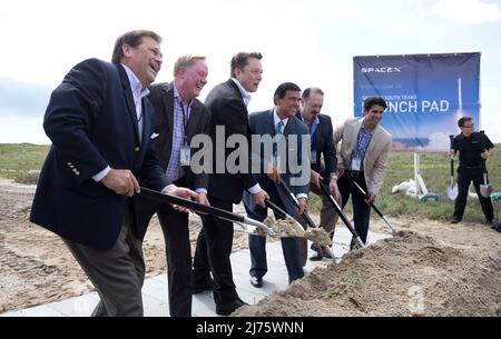 Boca Chica, Texas USA 22SEP14: ELON MUSK  (third from left), SpaceX CEO and co-founder, helps break ground on the Boca Chica, Texas site of the new SpaceX space port in far south Texas. The remote site east of Brownsville, Texas is two miles from the mouth of the Rio Grande River and Texas' border with Mexico.  The others shoveling are Texas legislators; Texas Gov. Rick Perry stands in the background with two shovels. ©Bob Daemmrich Stock Photo