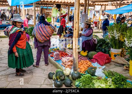 Senior Indigenous Quechua Women Shopping For Fruit and Vegetables At The Sunday Market In The Village Of Chinchero, Cusco Region, Peru. Stock Photo