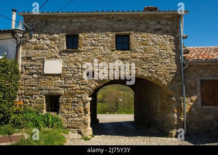 An old residential building in the historic medieval village of Roc near Buzet in Istria, western Croatia. A town gateway runs through the building Stock Photo