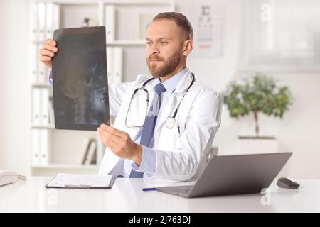 Young male doctor examining x ray image in an office Stock Photo