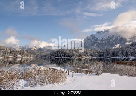 The Lautersee above Mittenwald in the fresh snow of a beautiful winter day with footbridge, in the background the Western Karwendel Stock Photo
