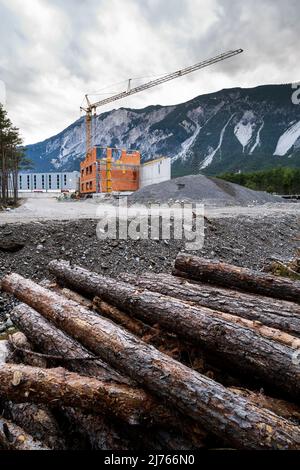 A construction site in the last remaining mountain forest in the Inn valley near Haiming. Cleared pine trees in the foreground. Stock Photo