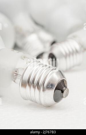 Close shot of glass incandescent light bulb cap with E27 / Edison Screw 27mm thread fitting. For illuminating, UK lighting industry, lighting abstract Stock Photo