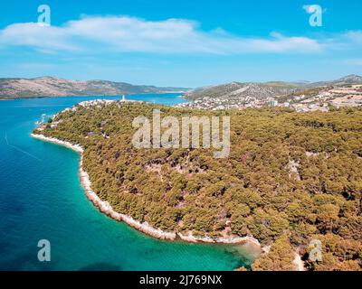 You can see the sea and a part of the area of Seget Vranjica in Croatia from above. In the foreground a lot of forest. Stock Photo