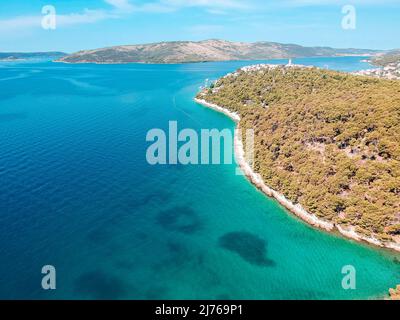 You can see the sea and a part of the area of Seget Vranjica in Croatia from above. In the foreground a lot of forest. Stock Photo