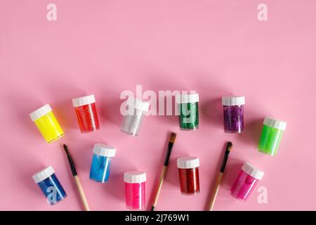 Paints and paintbrushes on pink background, flat lay with copy space. Art and crafts concept Stock Photo
