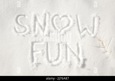 Words "snow fun" with a heart for letter o written in snow; concept of fun that can be had on a snowy winter day Stock Photo