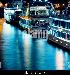 Harbor tour ships in Hamburg harbor, at night. Stock Photo