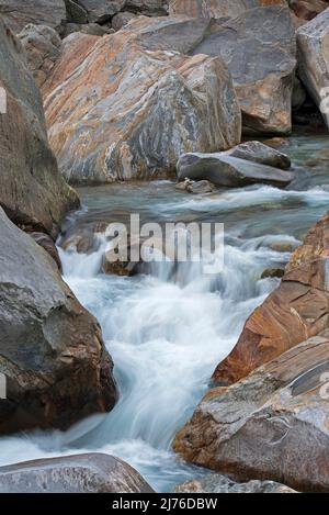 Verzasca river course, water flowing through colored banded rocks, Verzasca valley, Switzerland, canton Ticino Stock Photo