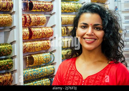 young indian woman show traditional ethnic bracelets in her small market in Goa Stock Photo
